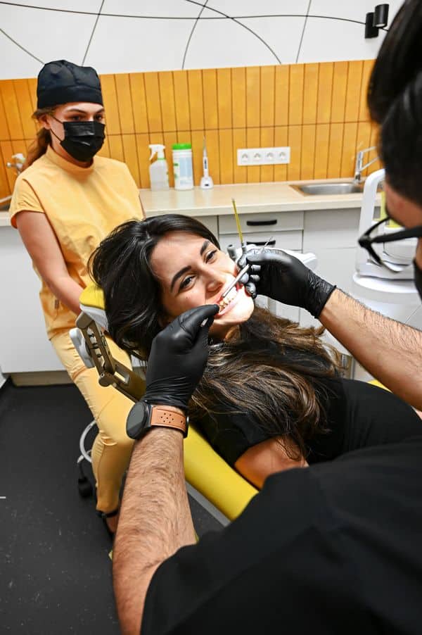 fogszabályozó szakorvos egy nőt vizsgál, hogy alkalmasak-e a fogai a fogszabályozásra.